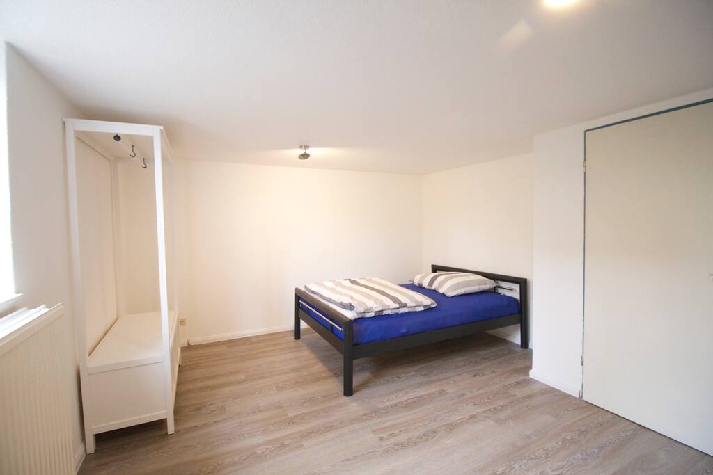 Zimmer mit Doppelbett, Tisch und Stühlen und Kleiderschrank