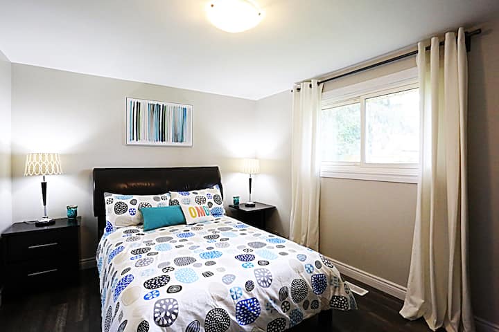 ห้องนอนที่ 1: เตียงควีนไซส์พร้อมหน้าต่างบานใหญ่มองออกไปยังสวนหลังบ้าน