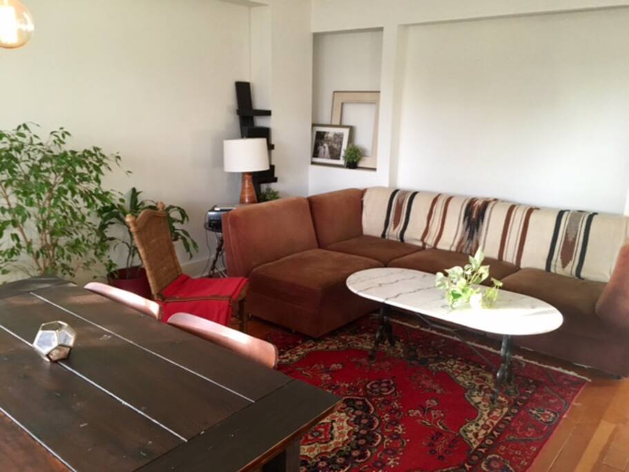 Living room with "L" couch and custom dinning table.