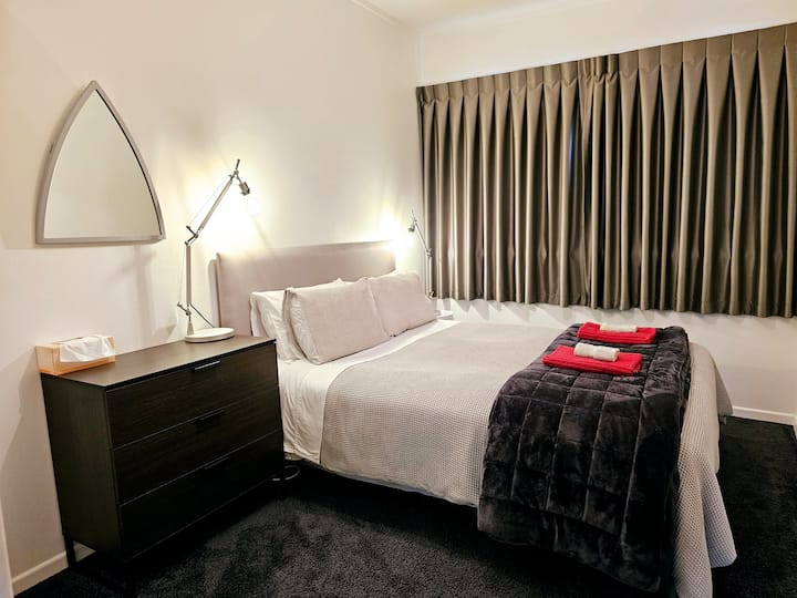 Chumba cha kulala cha fedha kilicho na kitanda aina ya queen.