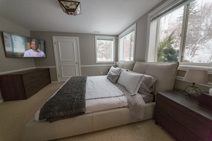 חדר שינה שני (הרבה אור טבעי!) עם שטיחים, מיטת עור קינג סייז, טלוויזיה חכמה, שידה וארון פרטי.