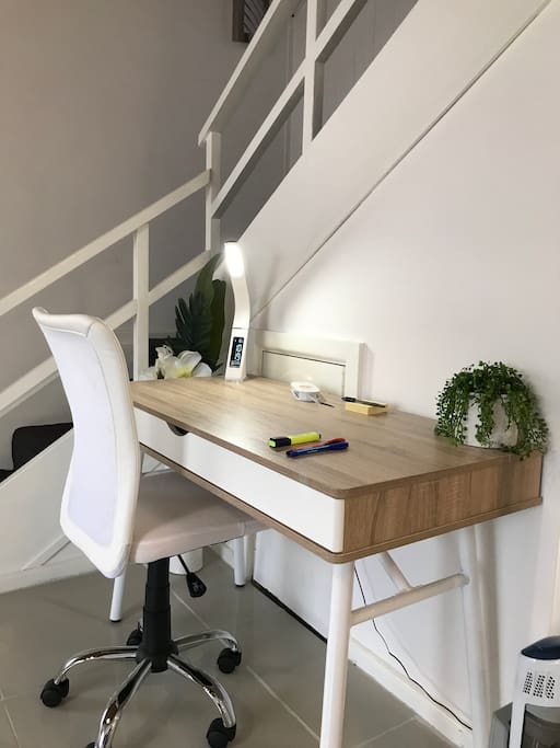 Large office workspace with desk lamp and charging station at your fingertips.