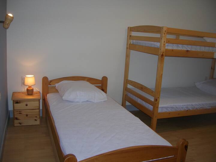 Chambre avec trois lits simples