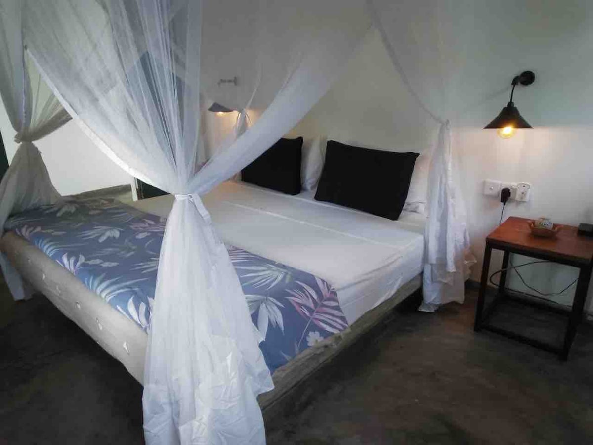 King size bed with new mattress, mosquito nets, air conditioning units, side tables, lights, hanging and shelf storage and plug sockets. The rooms have everything you need for a comfortable stay with us at Blue Breaks Villa.
