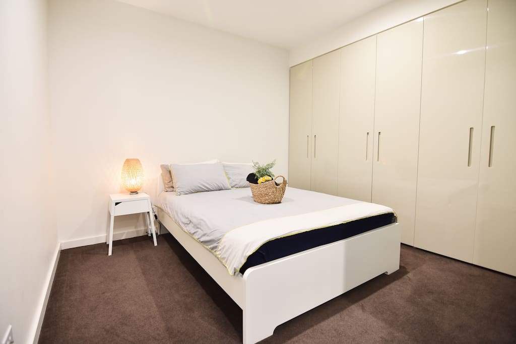 A bedroom with a queen sized bed & plush pillows.