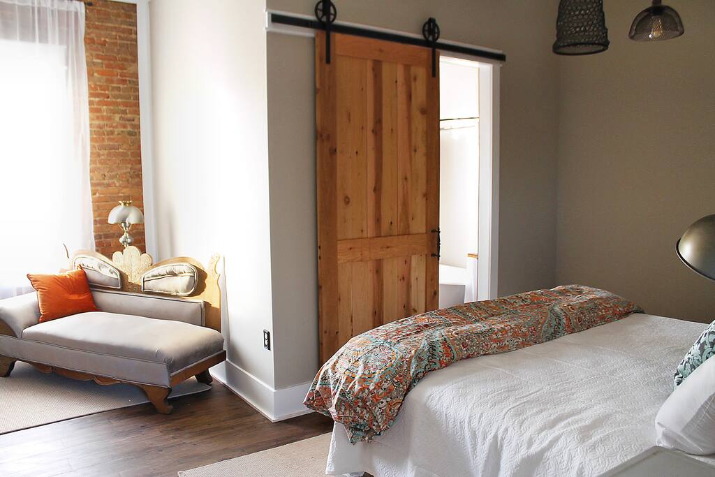 The bathroom door has a sliding barn door with unique rolling hardware.