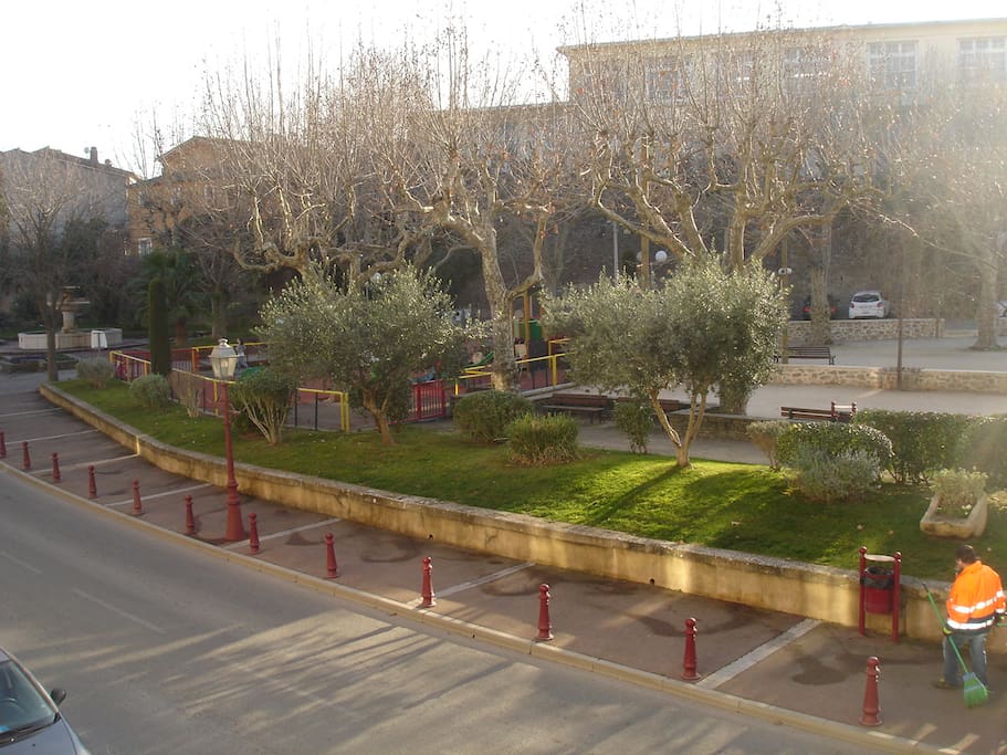 Vue de sur le balcon cote rue derrière les oliviers, l'aire de jeux pour les enfants