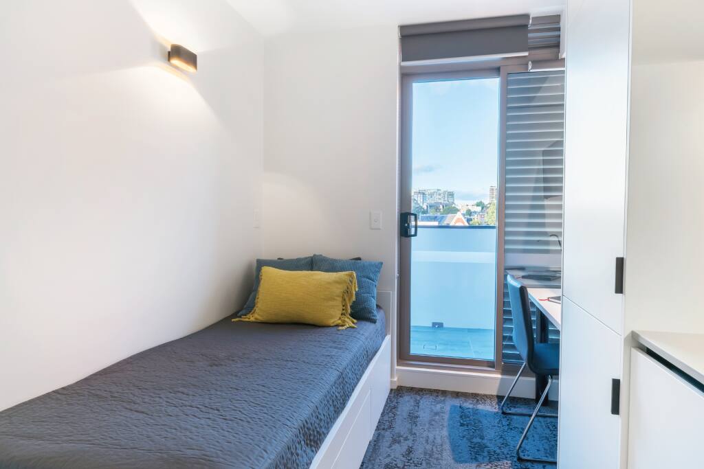 Bedroom 1 with balcony overlooking city skyline