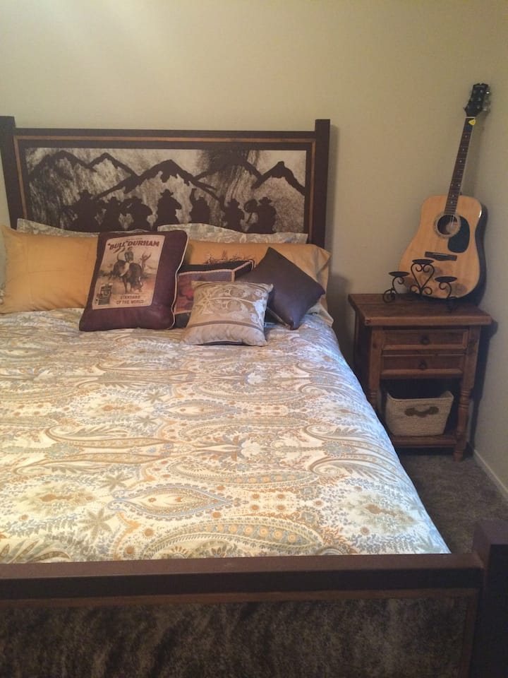 Priestranná spálňa s manželskou posteľou Queen, inteligentná televízia, komoda, minibar, chladnička a šatník.