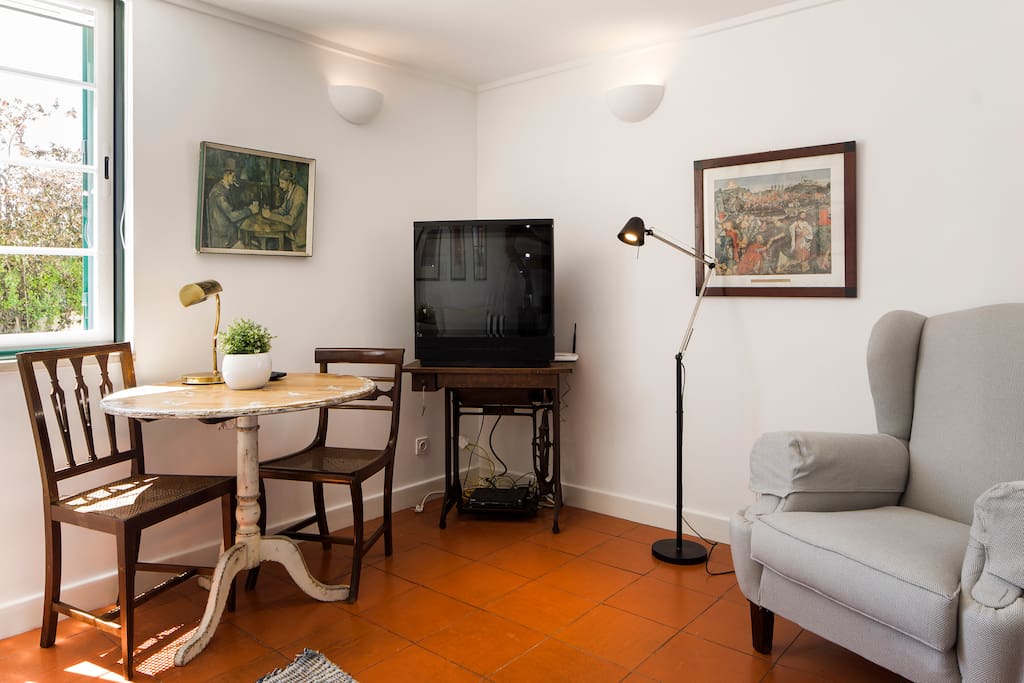 Sala,canto com TV e mesa.