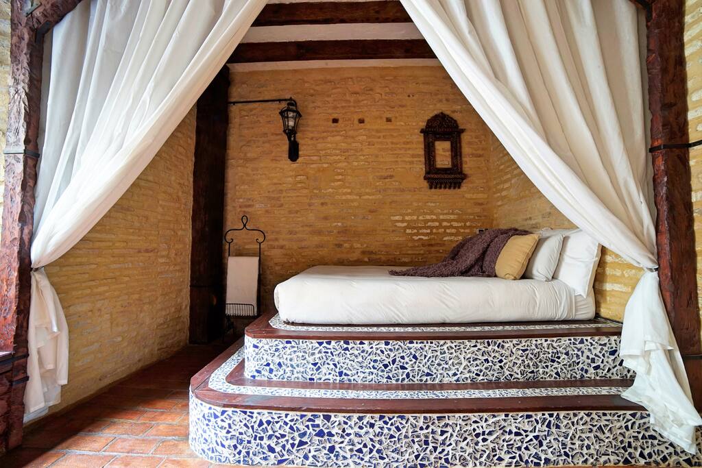 Linens from above for extra coziness. Close them when in bed for the extra snugness. Street style lamp and antique Spanish wall frame.
