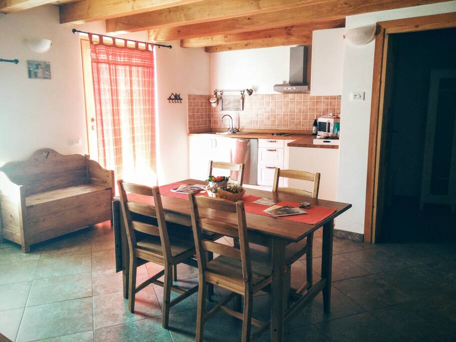 Zona giorno con cucina attrezzata, divano letto singolo e tv