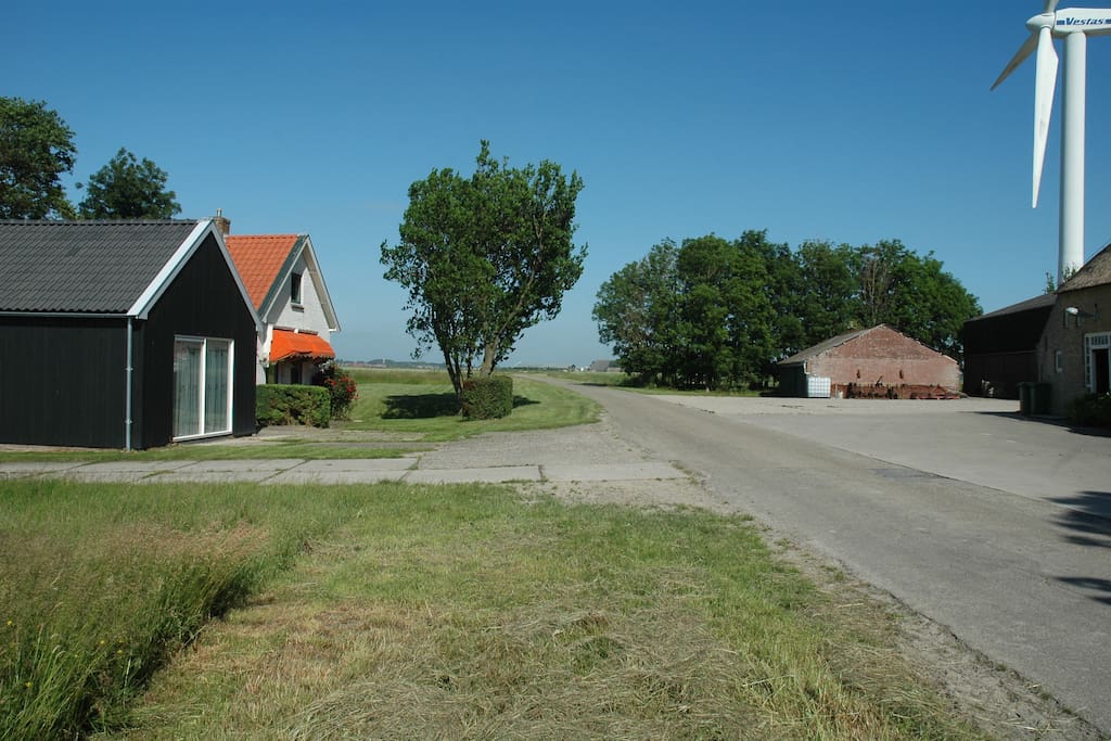 Het erf met de windmolen voor de groene stroom.