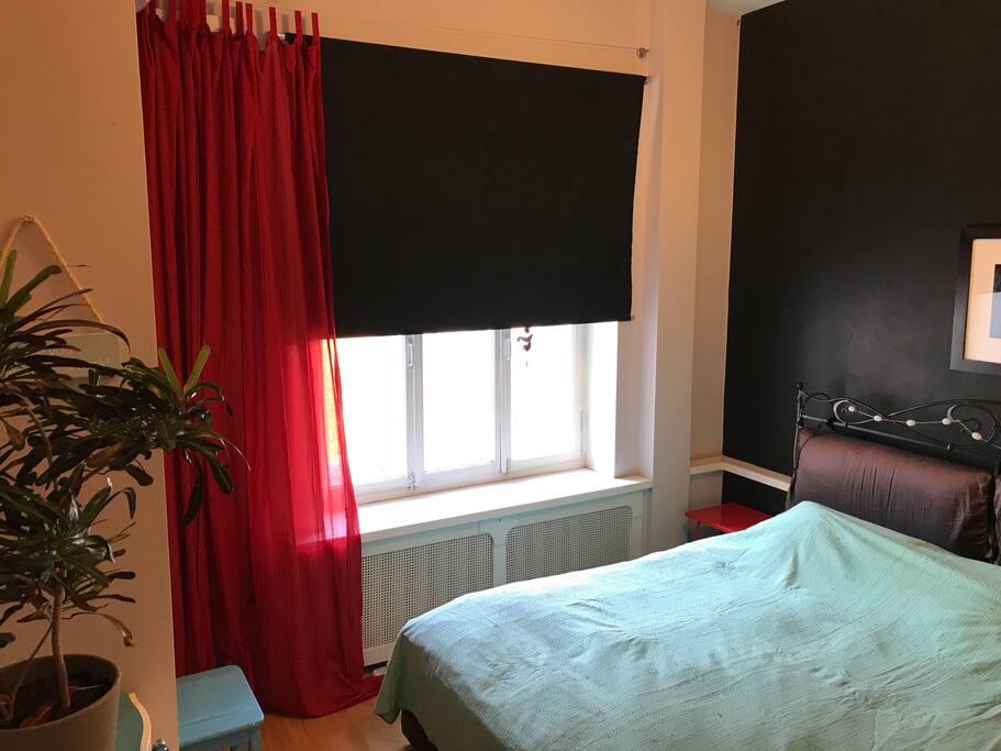 bedroom with a king size bed and a black-out curtain.