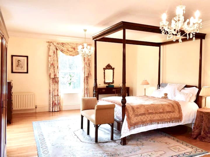 Dormitorio 1 con cama tamaño king con 4 camas tamaño king con vistas al río Swale y jardines.