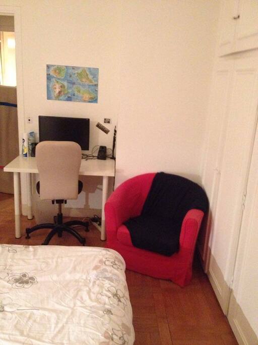 La chambre avec le bureau et un fauteuil.
