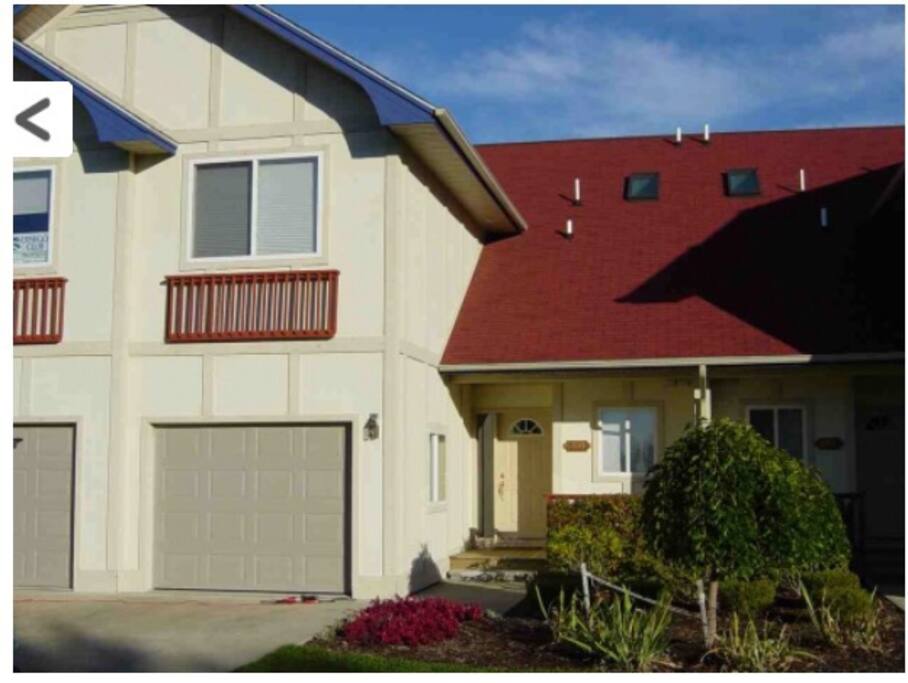 Front view of condo. Front porch with small sitting area. Large driveway with plenty of room to park cars.