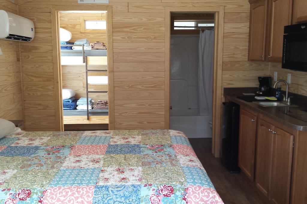 Tiny houses use every inch of space. Here you see the kitchen, bathroom, queen bed, and bunk rooms.