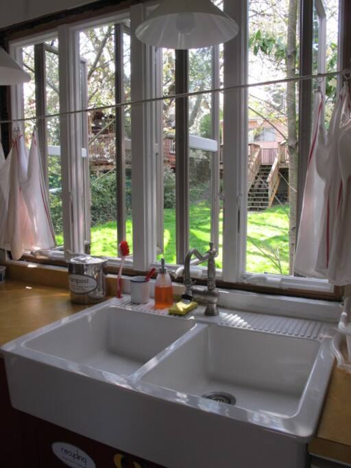 My neighbors behind me have a large back yard (and two nice dogs), which give fresh air and green to look at while doing your dishes. Food scrap container is to the left of the sink, recycling under the sink. (No recyclables or food scraps are allowed in Seattle trash.)