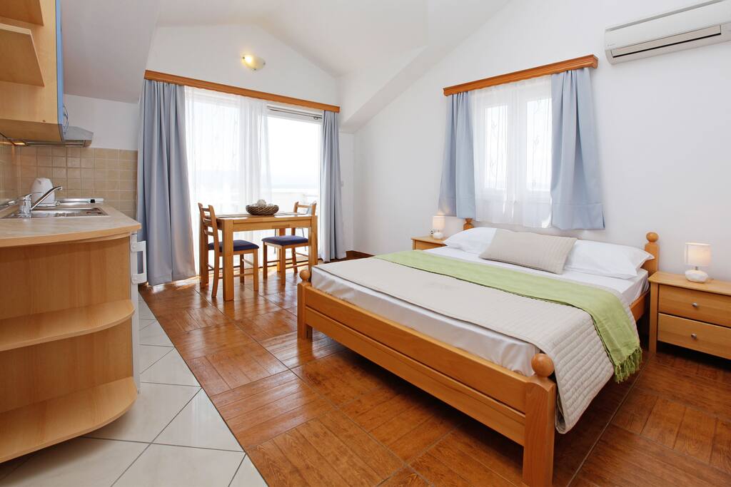 studio with bed, kitchen and adjoined dining area