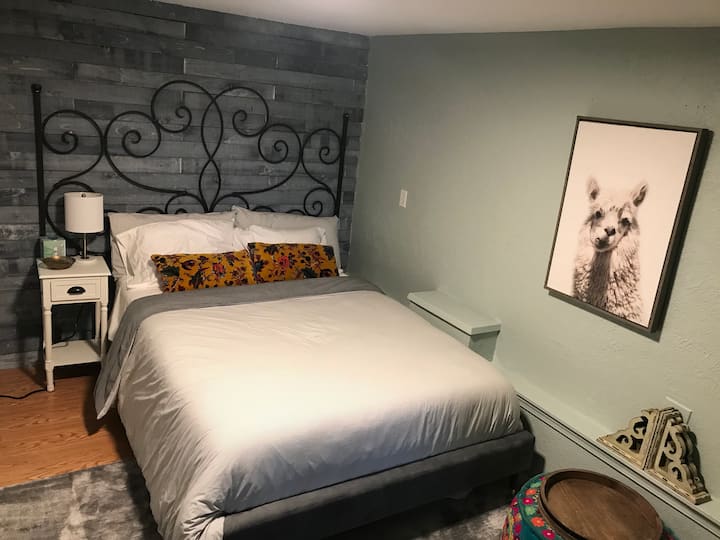 Bedroom #2 boasts a super comfy new mattress and trendy wood accent wall. There is also a desk and cozy chair.
