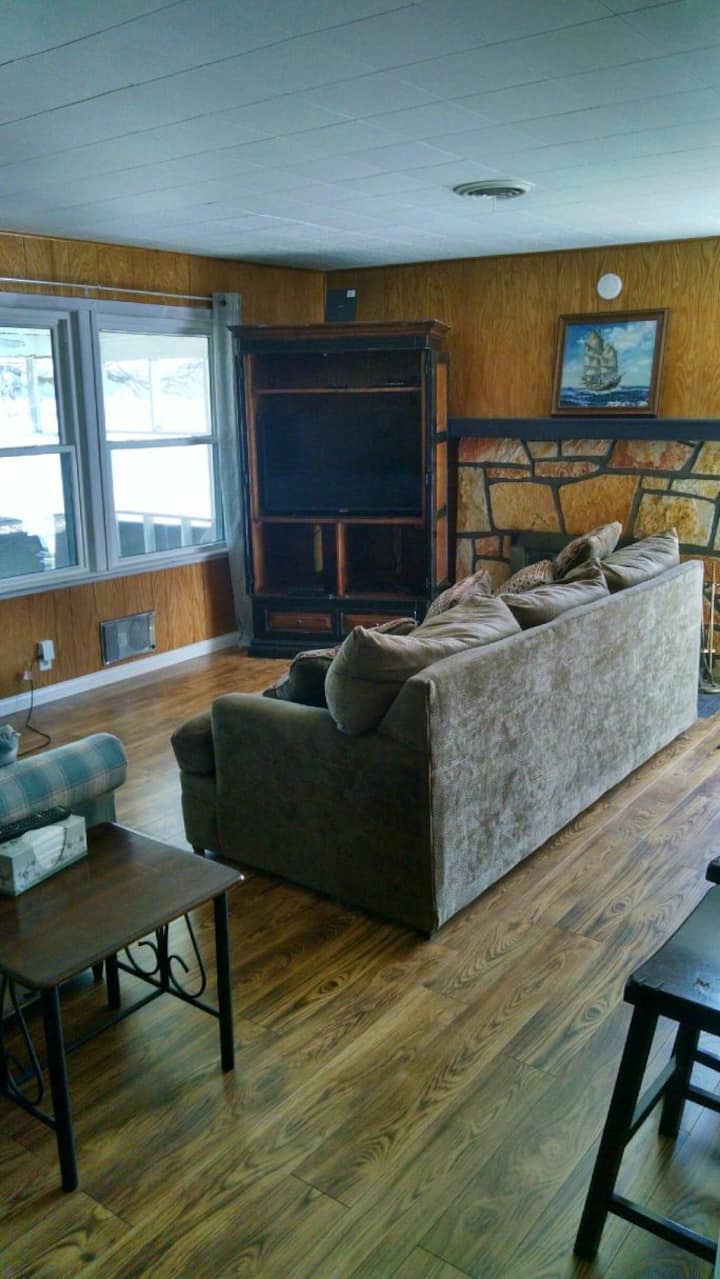 غرفة معيشة مع مدفأة وإطلالة جميلة على البحيرة