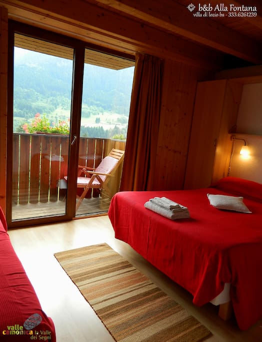 Camera tripla (con letto matrimoniale + letto singolo), ampia vetrata affacciata sul panorama della valle, balcone con sdraio, tv con lettore dvd, raccolta di libri e dvd (ed eventualmente giochi per bambini) a disposizione.
