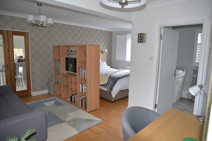 Წიგნების თაროს ეკრანის უკან არის ღია მოსასვენებელი სივრცე დიდი ზომის საწოლით. 