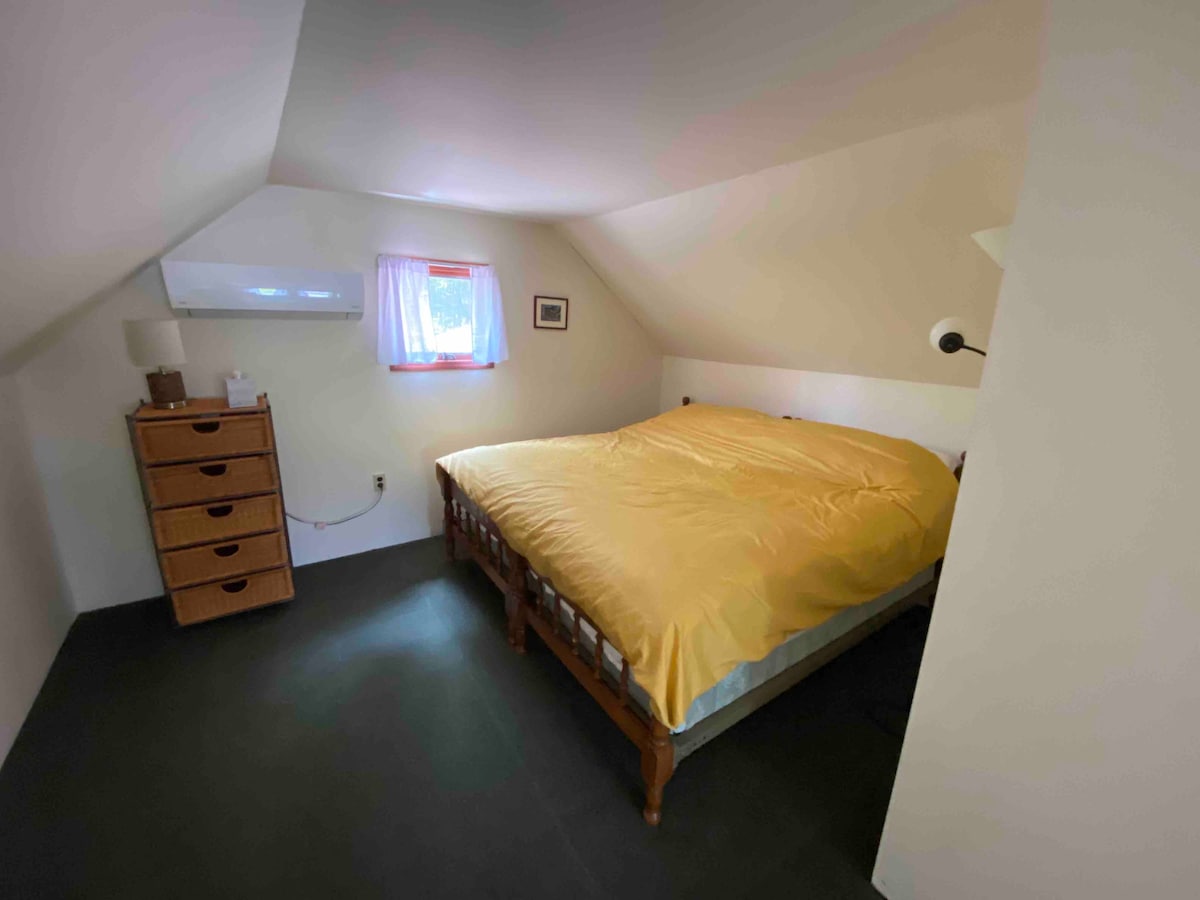 King bed in the attic bedroom shared with two twin beds and a half bath. 
