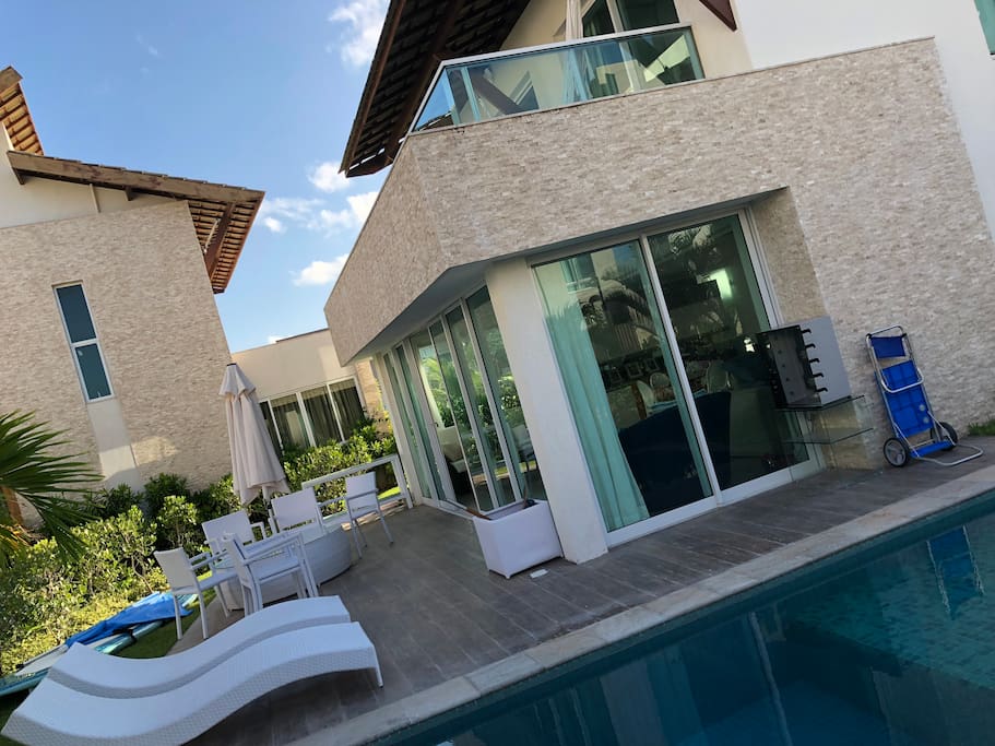 Varanda externa com piscina e churrasqueira elétrica