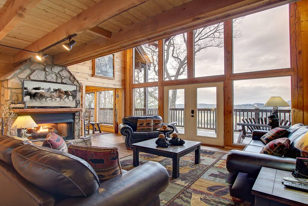 Living room with floor to ceiling windows, fireplace, and luxury furnishings