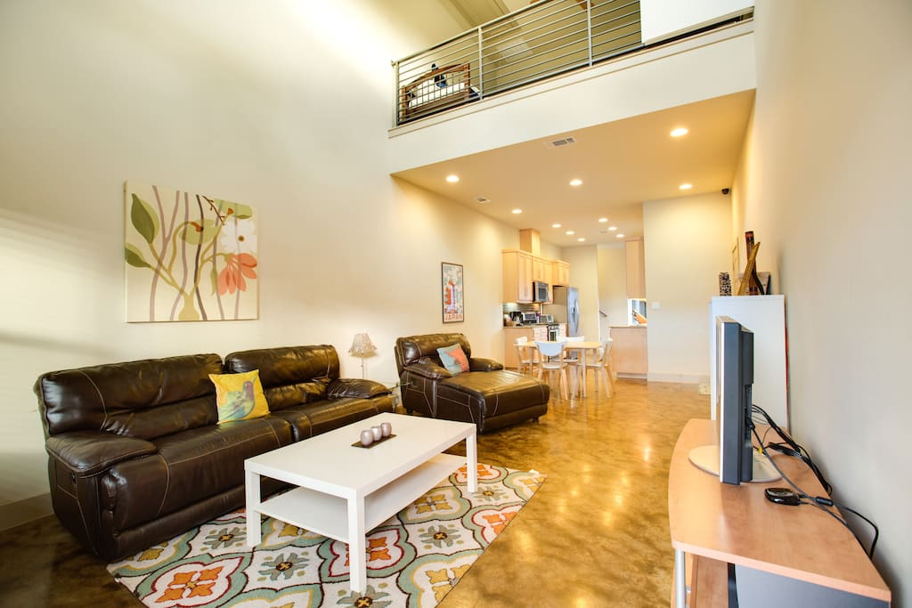 The open floorplan connects the living room with the dining, the kitchen, and the loft.