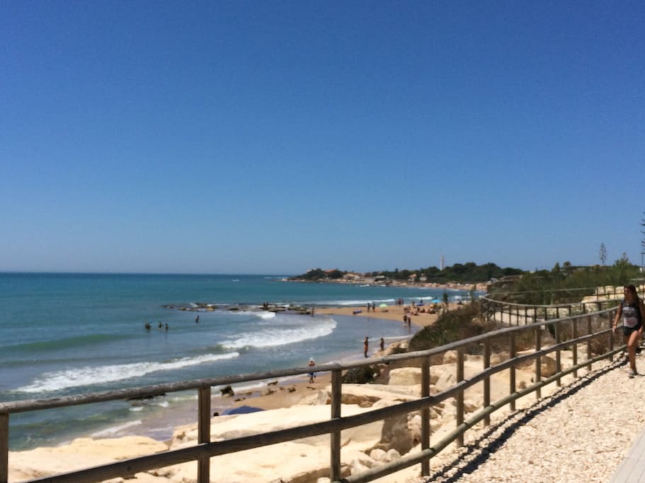 Spiaggia di Caucana in prossimità degli scavi archeologici. Sullo sfondo il faro di Punta Secca.