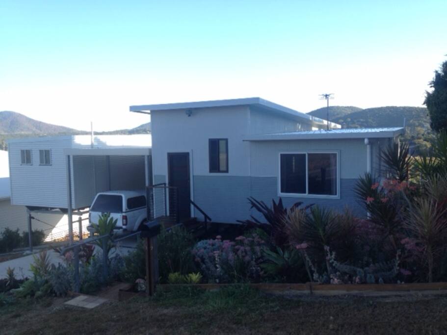 Front view of house. Guest room to left. Entrance to property through shared breezeway.guest carparking area on left