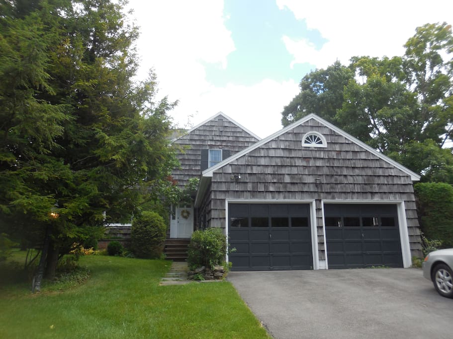 House has wooden deck, attached 2 car garage, on about acre of flat land