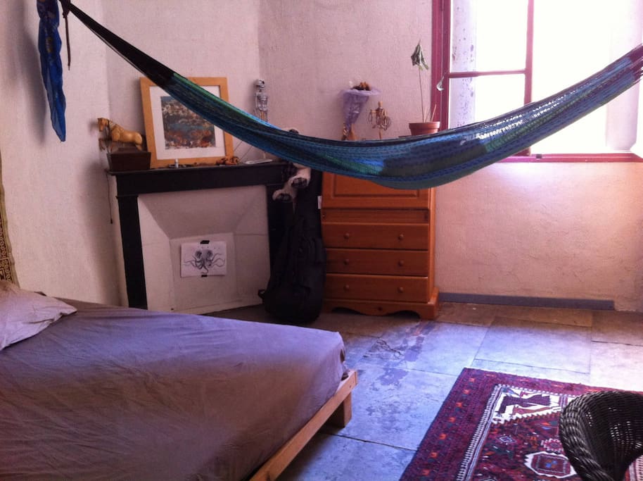 Chambre à lit double avec bureau, hammac et penderie.