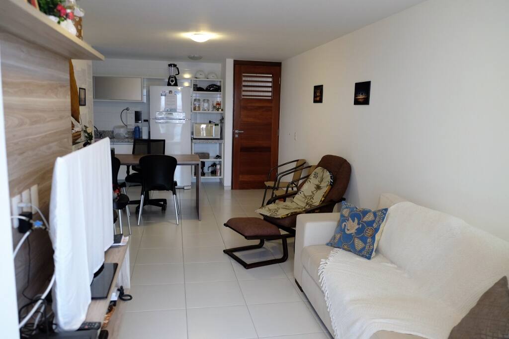 Sala com cozinha integrada e moveis novos.