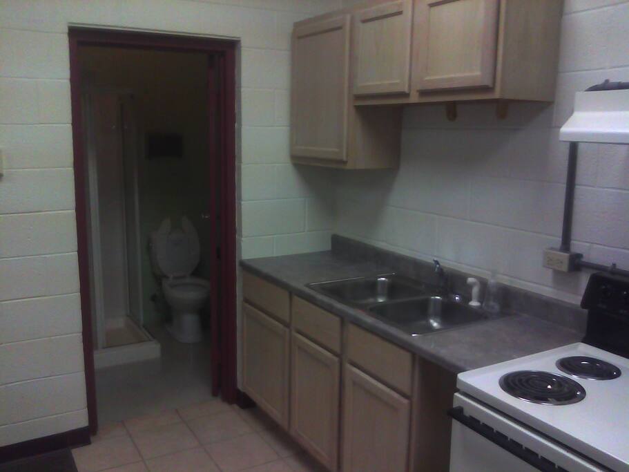 The kitchen area with doorway to bathroom