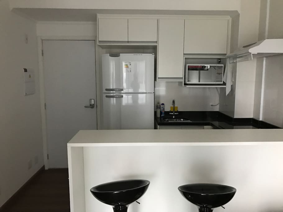 Cozinha completa, microondas com grill, geladeira espaçosa de 450 litros, cooktop, exaustor e armários repletos de utensílios que toda casa deve ter.