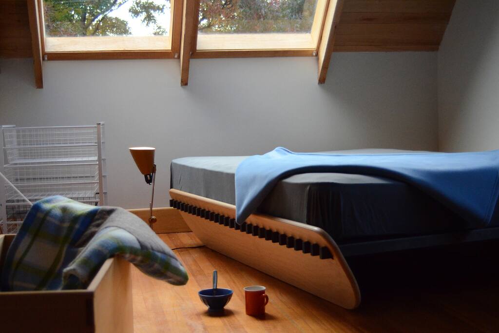 Mezzanine bedroom with bed under the skylight and stars.