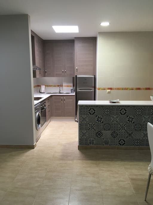 Cocina abierta con barra americana totalmente equipada.
