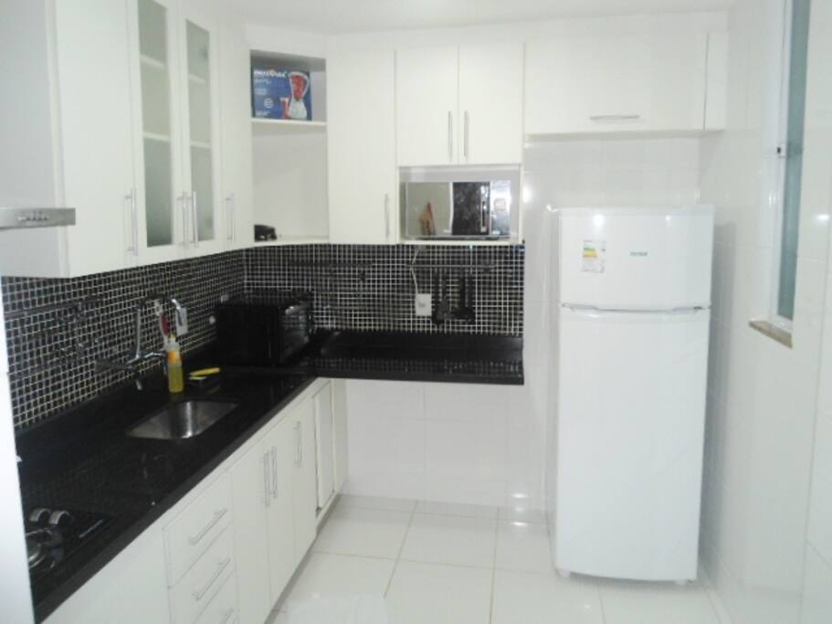 Cozinha bem ampla com geladeira, forno, microondas e liquidificador.