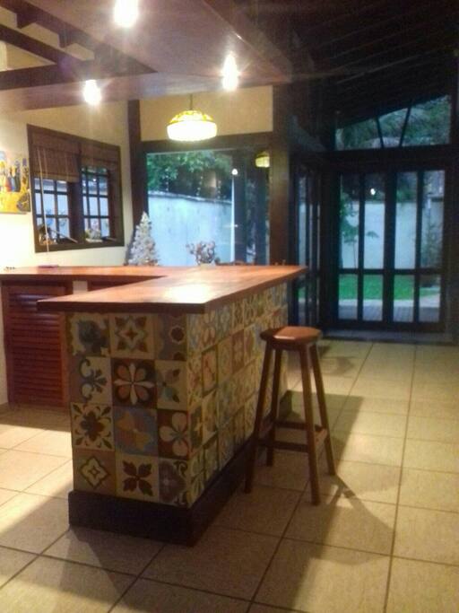 Está e a cozinha com balcão e banquinhos para um bate papo.