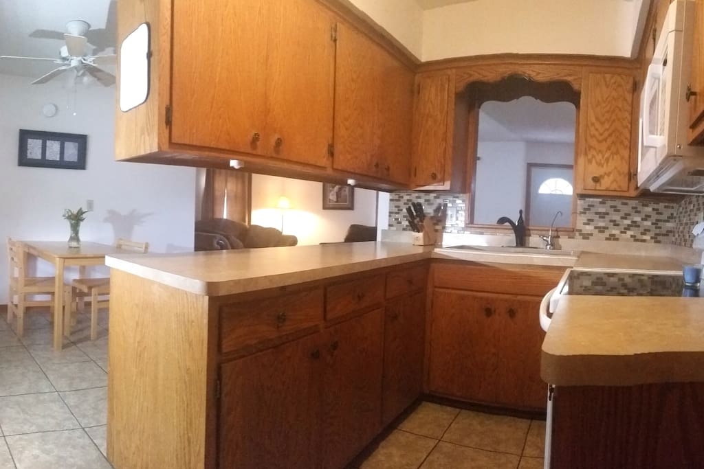 Fully stocked kitchen with stove and microwave.
