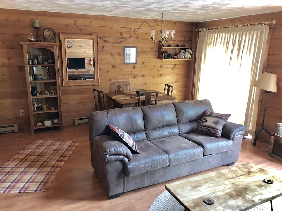 Living room, dining room, sliding glass door to deck, shelf with handmade pottery.