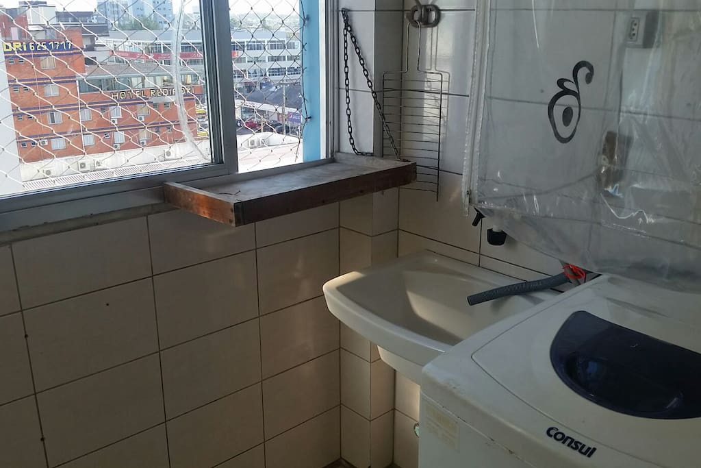 Área de serviço com máquina de lavar roupa e enxuta