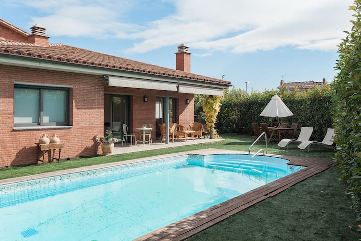 Casa grande con piscina y jardín.