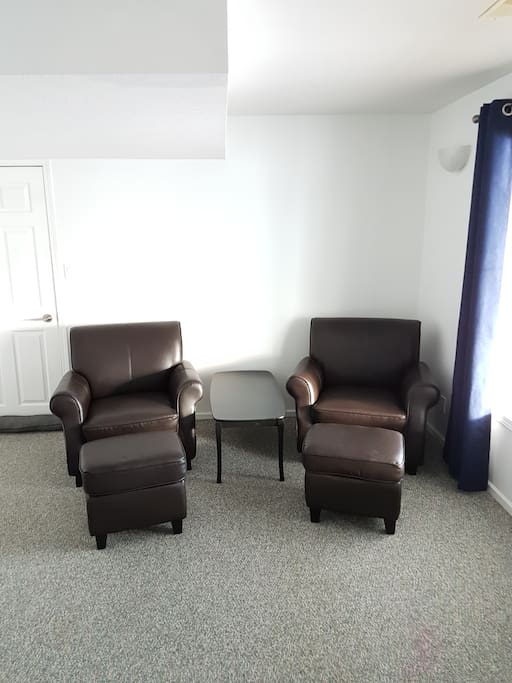 2 comfy chairs adjacent to the bed for relaxing