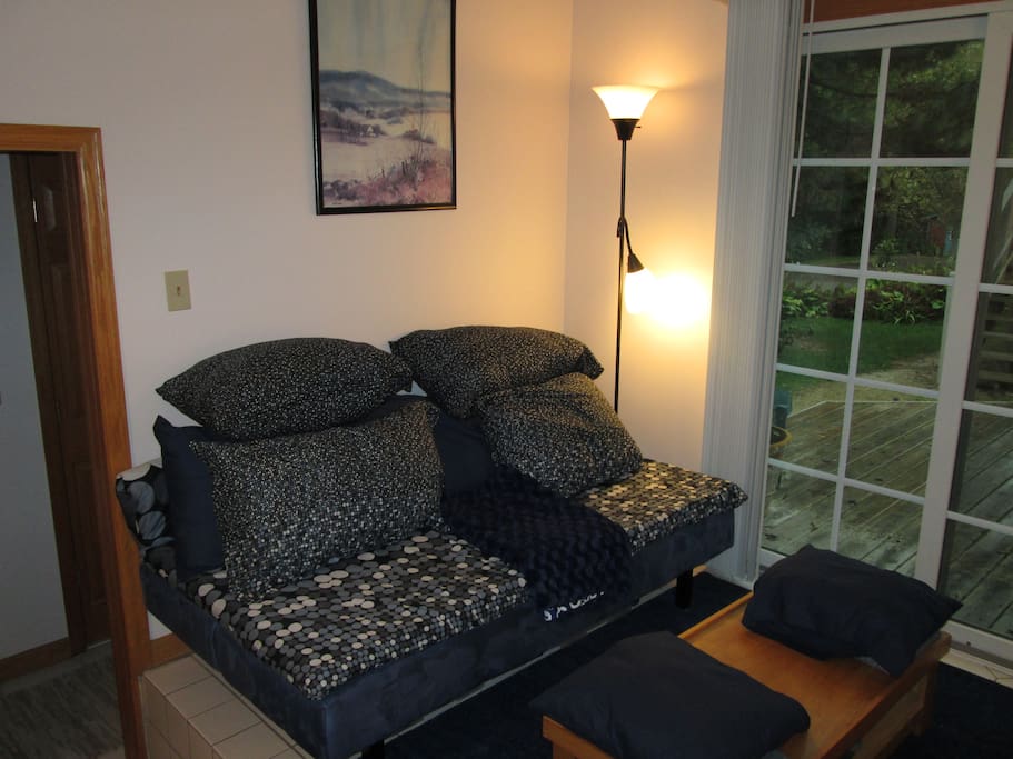 TV room with view to backyard deck & gardens. Futon & desk area.