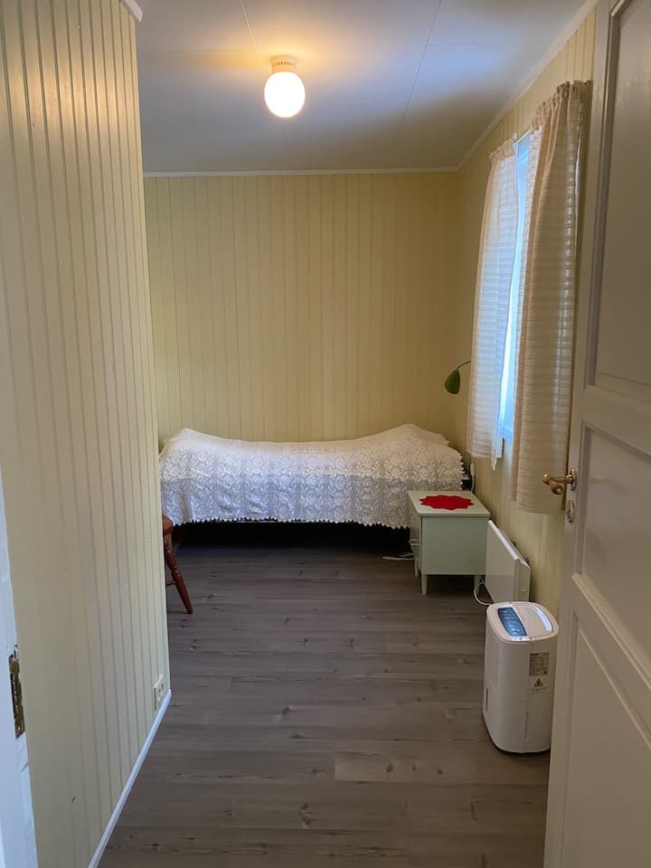 เตียงเดี่ยวพร้อมโต๊ะข้างเตียงในห้องนอน 2